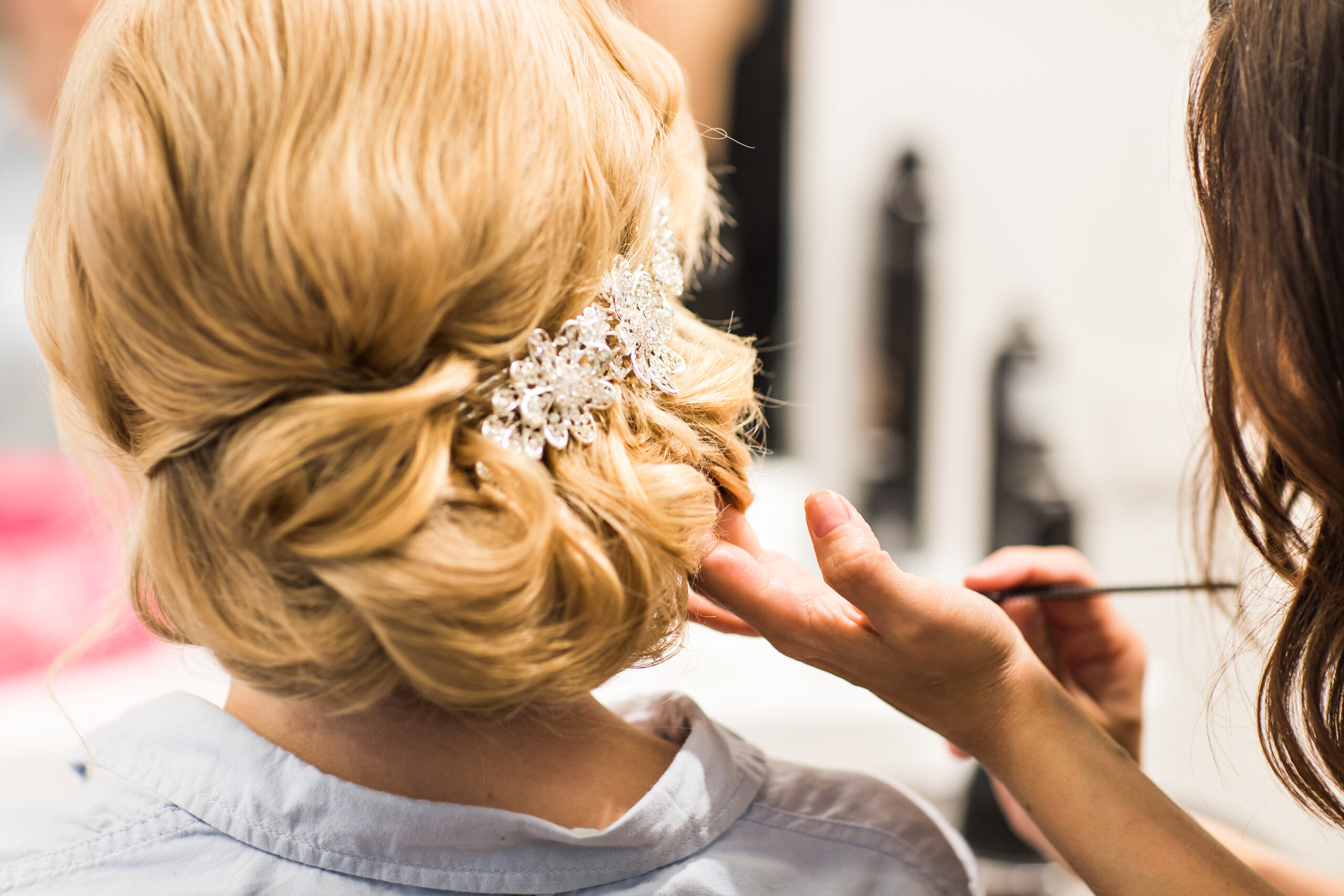 Hair stylist makes the bride before a wedding